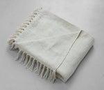 Neutral woven throw with delicate fringe edges