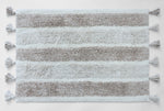 Plush striped bath mat with tassels
