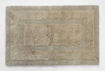 Plush beige bath mat with textured border