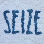 Plush bath mat with raised lettering